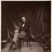 Prince Albert sits in a chair looking at the camera in a Victorian photograph.